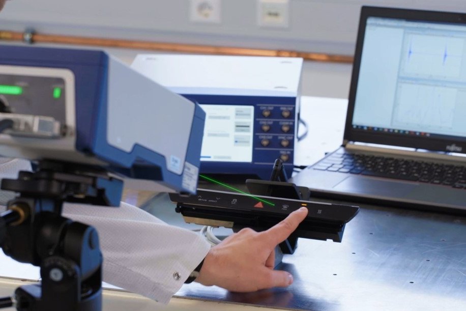 Measurement setup of haptic click-device with manual actuation and laser vibrometer capturing the out-of-plane surface motion Measurement setup of haptic click-device with manual actuation and laser vibrometer capturing the out-of-plane surface motion