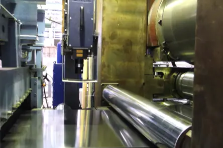 Laserbasierte Längen- und Geschwindigkeitsmessung an glänzendem Titanwalzband im industriellen Einsatz bei hohen Temperaturen.