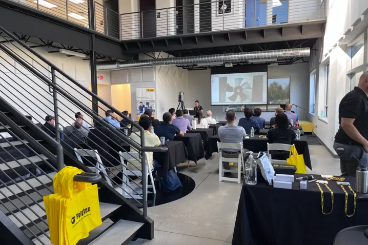Attendees at Polytec Training Day in Plymouth engage in laser vibrometry lecture and live demonstrations in a modern conference room.